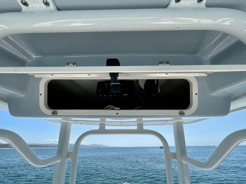 Slide: The Image of 2022 Robalo R230 Center Console boat with open storage compartment, ocean view in background. - 19