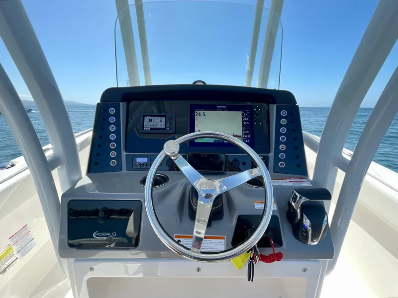 Slide: The Image of 2022 Robalo R230 Center Console boat dashboard with steering wheel and navigation display. - 20