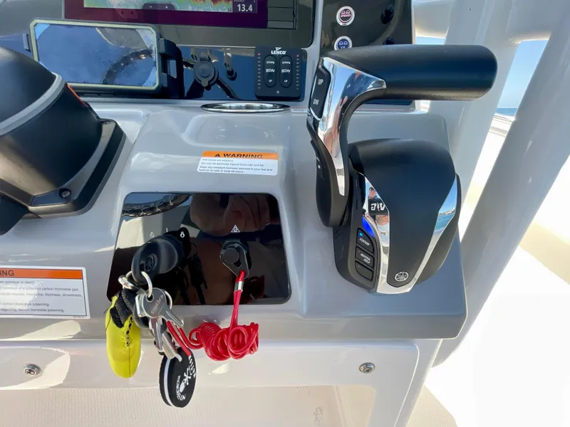 Slide: The Image of 2022 Robalo R230 Center Console dashboard with controls and keys. - 22