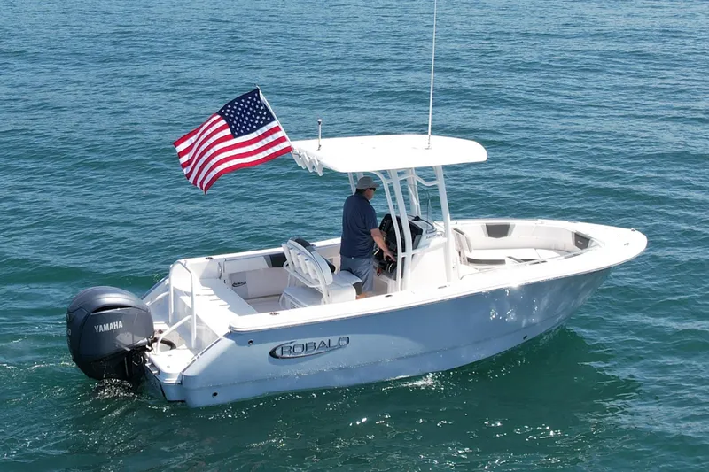 Slide: The Image of 2022 Robalo R230 Center Console boat with American flag on open water. - 3