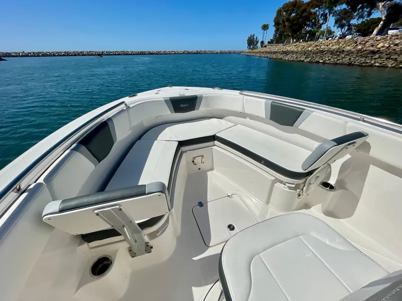 Slide: The Image of 2022 Robalo R230 Center Console boat with spacious seating, docked in calm waters. - 8