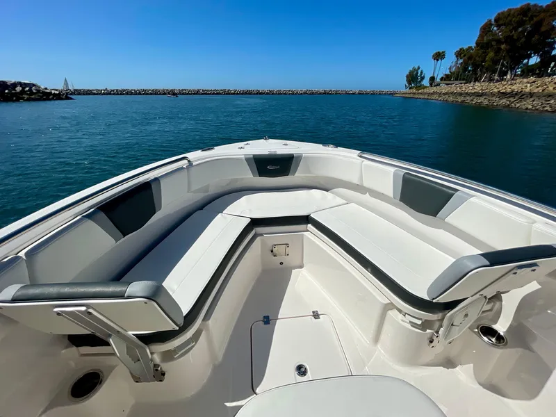 Slide: The Image of 2022 Robalo R230 Center Console boat with spacious seating, docked in a serene harbor. - 9