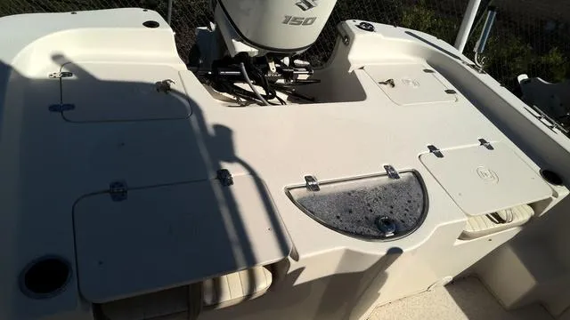 Slide: The Image of 2018 Carolina Skiff 238 DLV boat deck with storage compartments and outboard motor. - 7