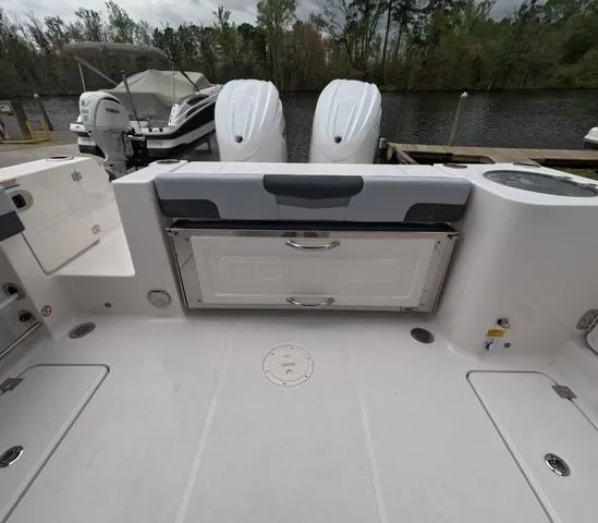 Slide: The Image of 2025 Robalo 257 Dual Console boat with twin engines docked by a serene river. - 11