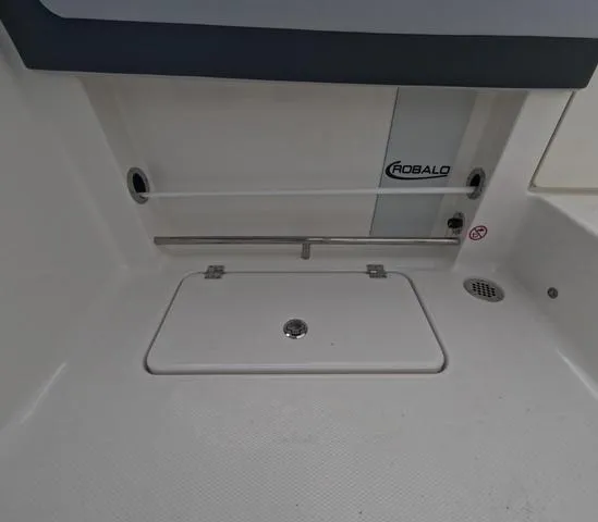 Slide: The Image of 2025 Robalo 257 Dual Console boat interior with storage compartment and drain. - 16