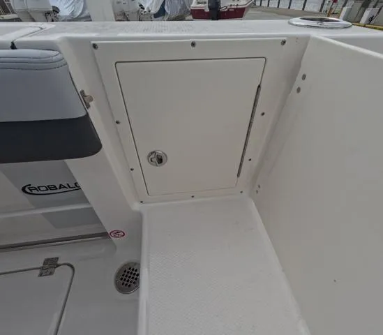 Slide: The Image of 2025 Robalo 257 Dual Console boat interior with storage compartment and seating. - 18