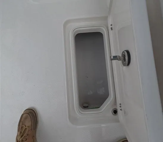 Slide: The Image of 2025 Robalo 257 Dual Console boat storage compartment with open hatch. - 22