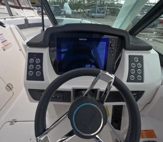 Slide: The Image of 2025 Robalo 257 Dual Console dashboard with steering wheel and Simrad display. - 27