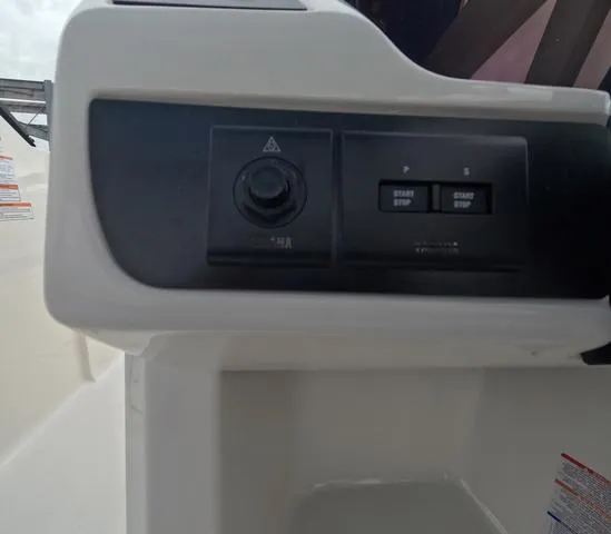 Slide: The Image of Control panel of 2025 Robalo 257 Dual Console boat, featuring start/stop buttons. - 32