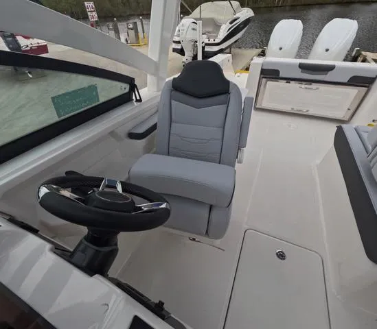 Slide: The Image of 2025 Robalo 257 Dual Console boat interior with sleek seating and modern steering wheel. - 35