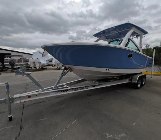 Slide: The Image of 2025 Robalo 257 Dual Console boat on trailer, blue hull, overcast sky. - 4