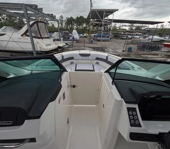 Slide: The Image of 2025 Robalo 257 Dual Console boat interior at a marina, showcasing seating and controls. - 44