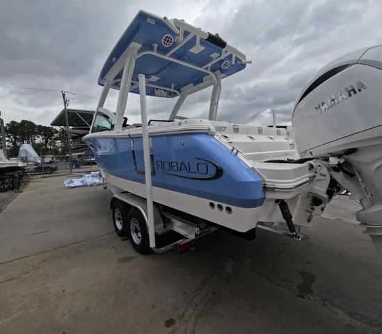 Slide: The Image of 2025 Robalo 257 Dual Console boat on trailer, featuring Yamaha engine, under cloudy sky. - 6