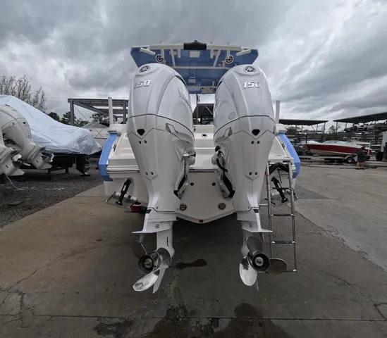 Slide: The Image of 2025 Robalo 257 Dual Console boat with twin 150 HP outboard engines, docked outdoors. - 7