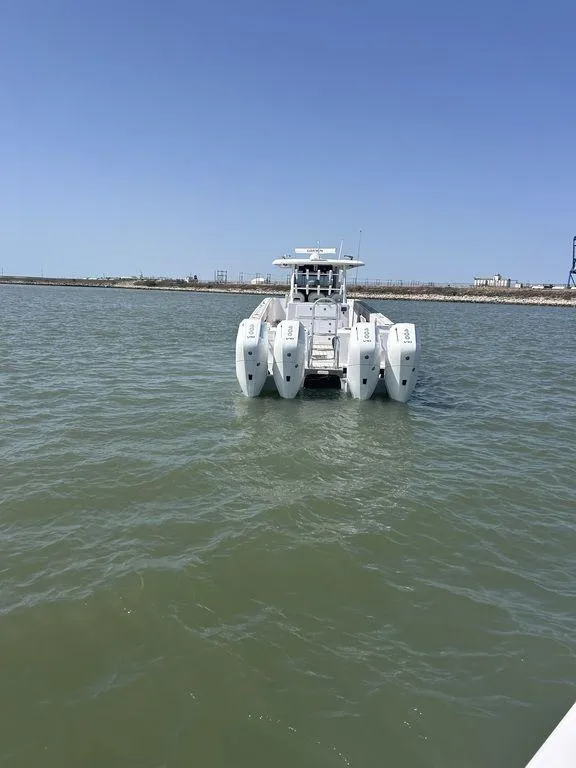Slide: The Image of 2024 Twin Vee 400 GFX catamaran on calm water under clear blue sky. - 11