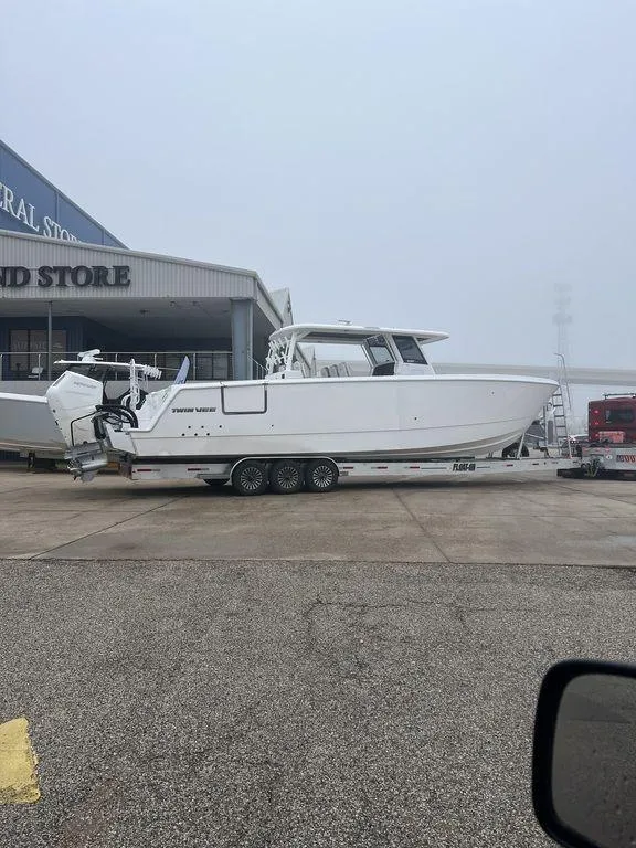 Slide: The Image of 2024 Twin Vee 400 GFX boat with multiple engines on open water. - 14