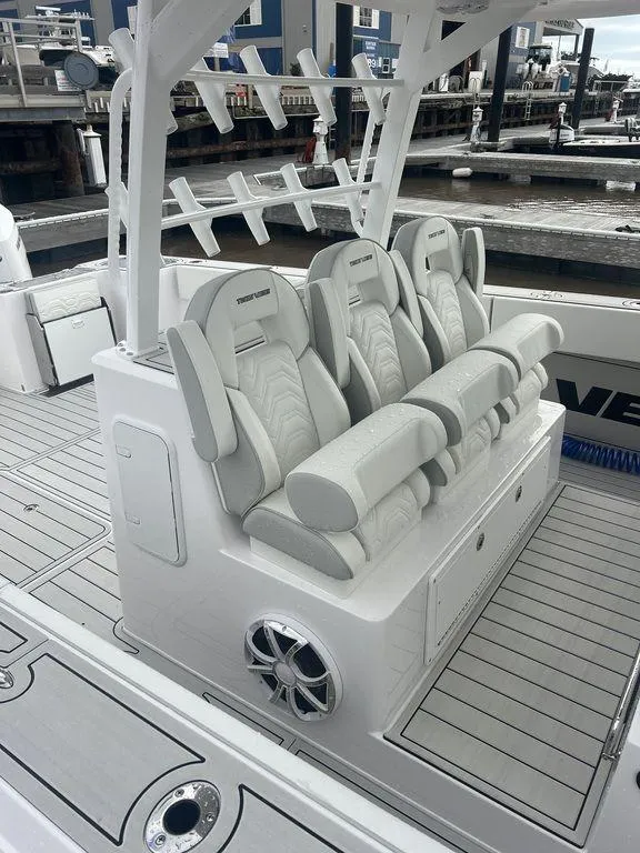 Slide: The Image of 2024 Twin Vee 400 GFX boat with luxurious seating and modern design at a marina. - 23