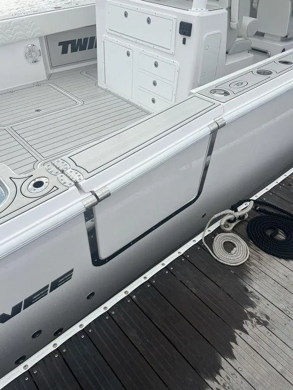 Slide: The Image of 2024 Twin Vee 400 GFX boat docked, showcasing sleek design and deck features. - 27