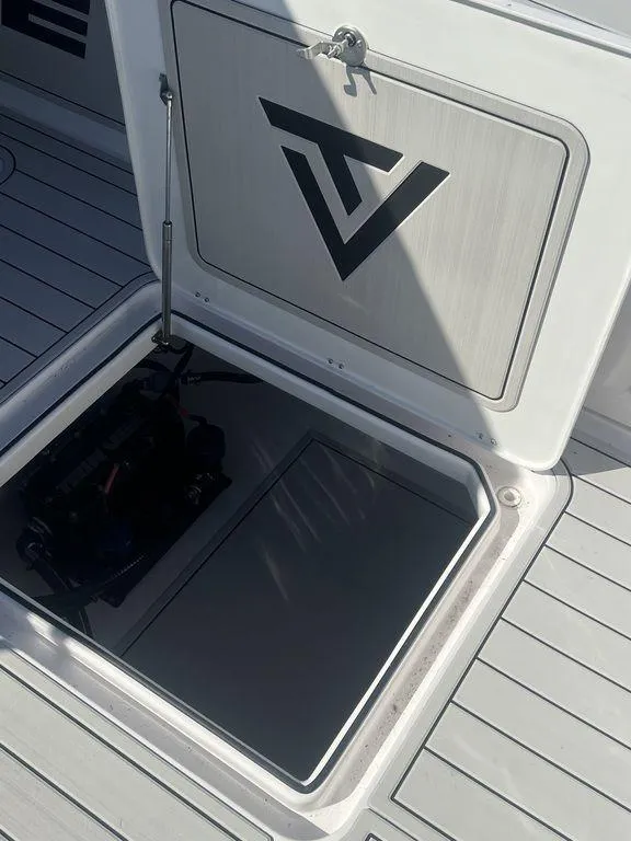 Slide: The Image of 2024 Twin Vee 400 GFX boat storage compartment with logo on hatch. - 28