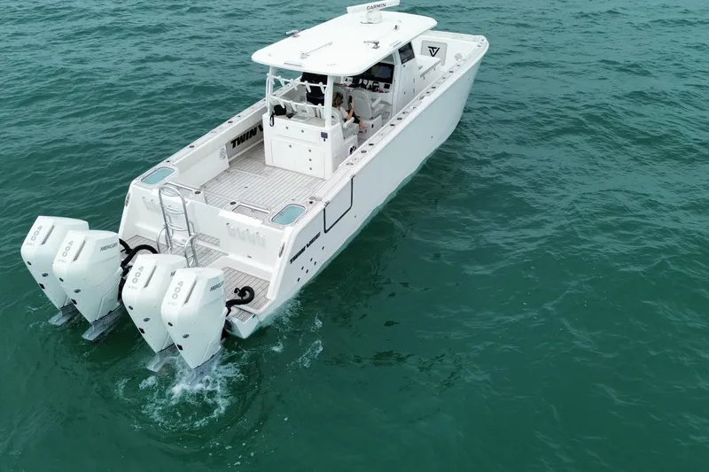Slide: The Image of 2024 Twin Vee 400 GFX CC boat cruising on open water, rear view. - 37