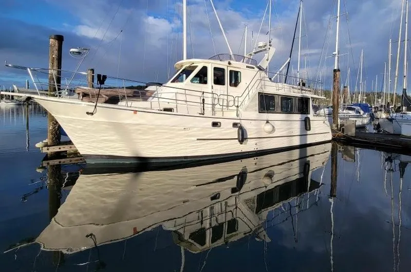 Slide: The Image of 2006 North Pacific 42 yacht docked in a marina, reflecting on calm water. - 0