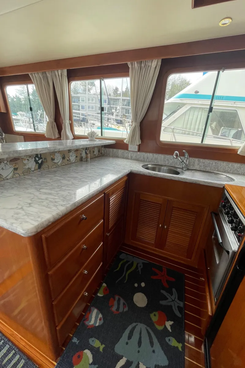Slide: The Image of Interior of 2006 North Pacific 42 yacht with marble countertops and wooden cabinetry. - 12