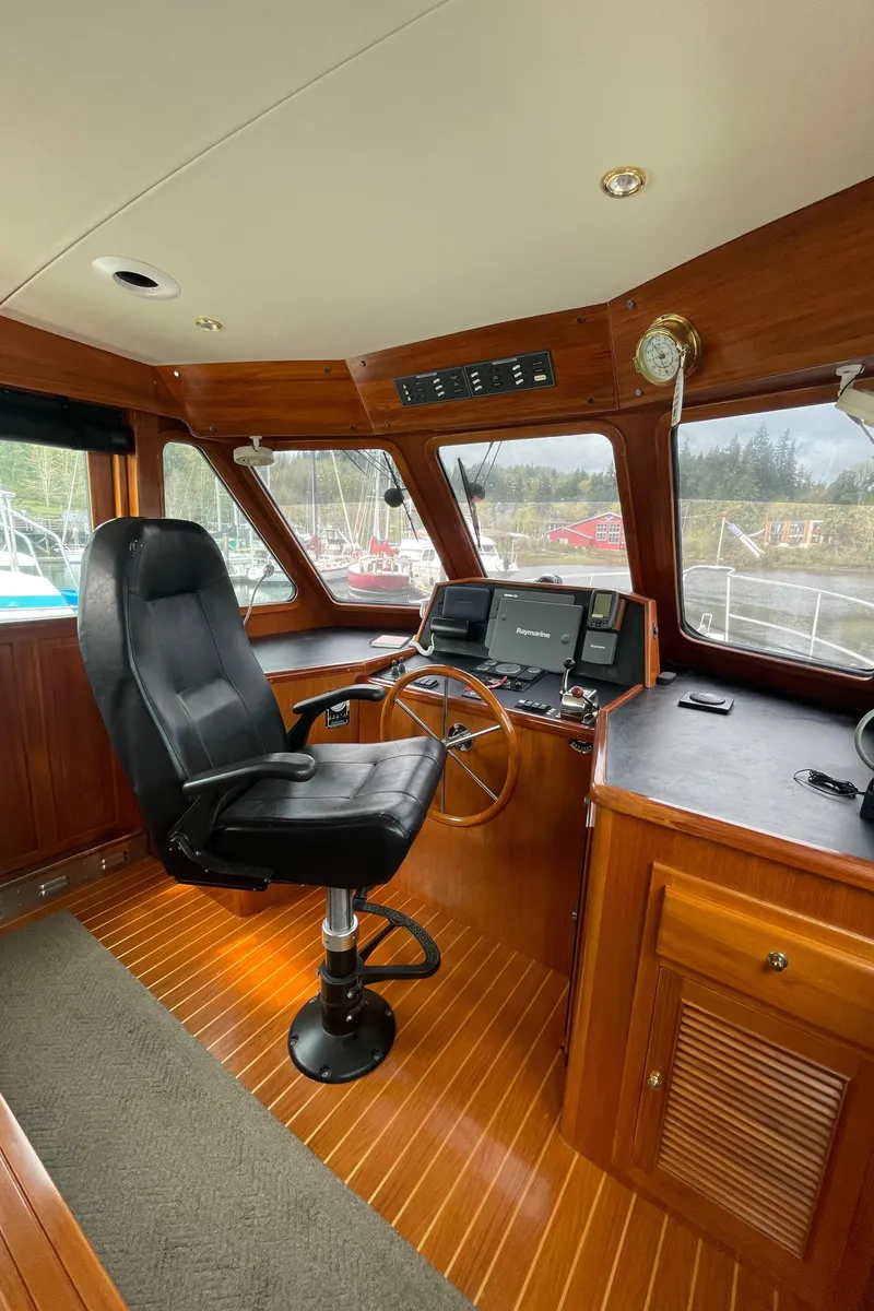 Slide: The Image of 2006 North Pacific 42 boat interior with helm, black captain's chair, and navigation equipment. - 17