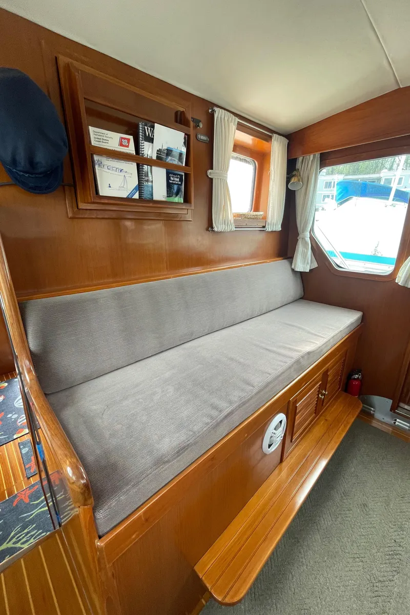Slide: The Image of Interior of 2006 North Pacific 42 boat with cushioned seating and wooden accents. - 18