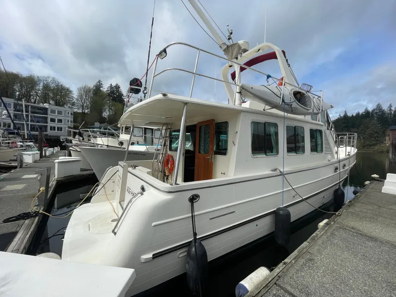 Slide: The Image of 2006 North Pacific 42 yacht docked at marina, featuring spacious deck and classic design. - 2