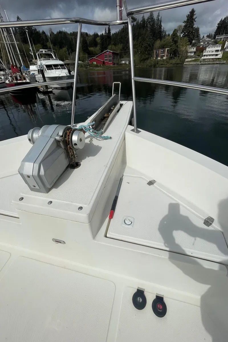Slide: The Image of 2006 North Pacific 42 boat deck with anchor system, docked in a serene marina. - 21