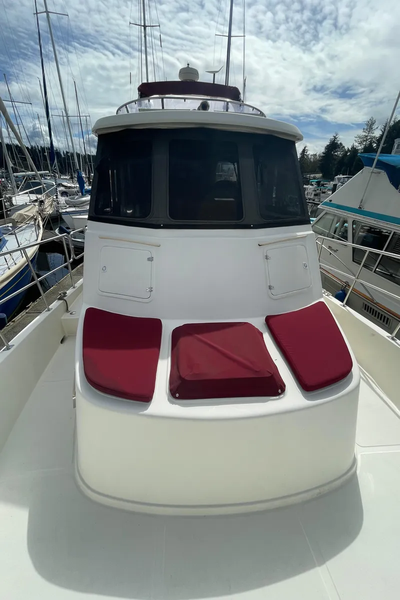 Slide: The Image of 2006 North Pacific 42 yacht with red cushions, docked in a marina under a cloudy sky. - 22