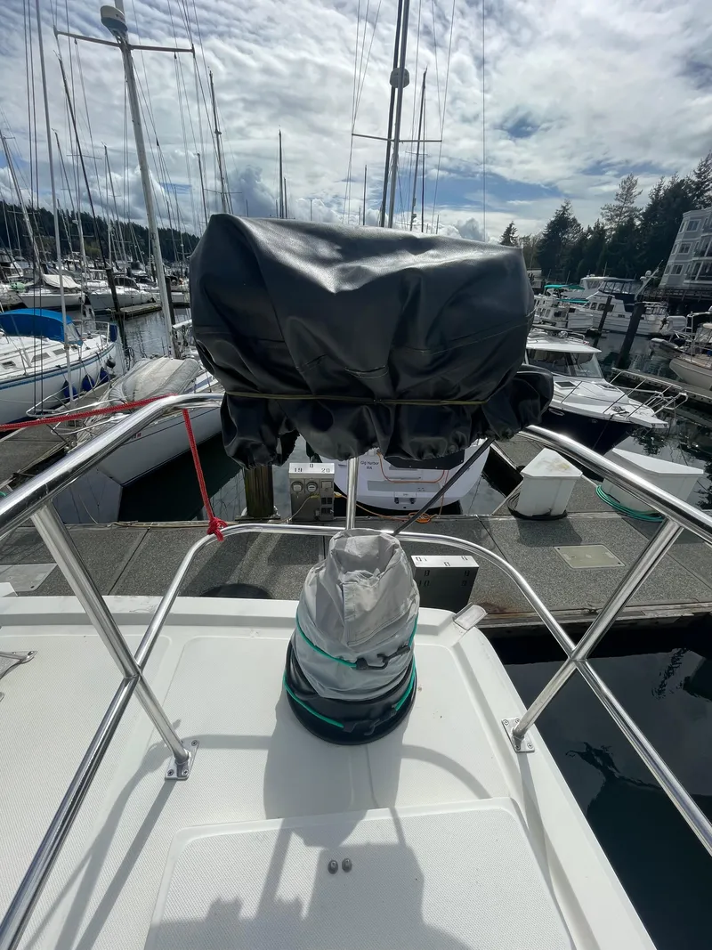 Slide: The Image of 2006 North Pacific 42 yacht at marina, covered equipment on deck, surrounded by other boats. - 25