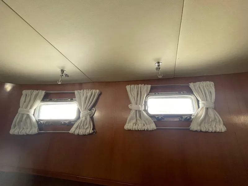 Slide: The Image of Portholes with white curtains in a 2006 North Pacific 42 boat interior. - 29