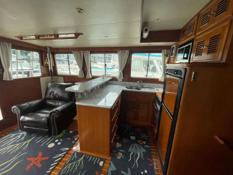 Slide: The Image of Interior of 2006 North Pacific 42 yacht with kitchen, leather chair, and nautical-themed decor. - 8
