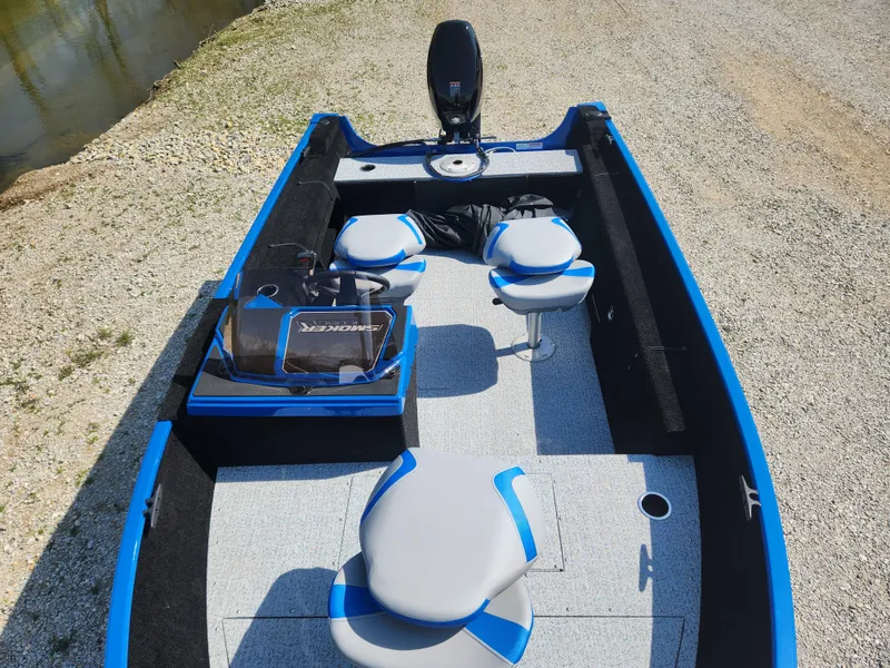 Slide: The Image of 2025 Smoker Craft Lazer 161 boat with seating and storage, parked on gravel near water. - 14