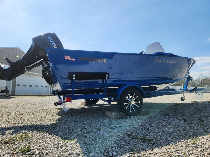 Slide: The Image of 2025 Smoker Craft Lazer 161 boat with Suzuki outboard motor by a river. - 3