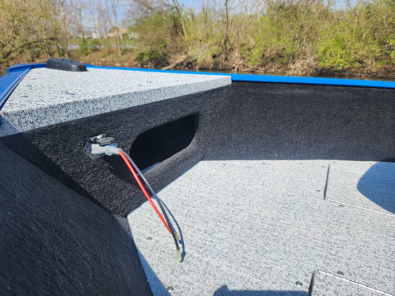 Slide: The Image of 2025 Smoker Craft Lazer 161 boat interior with wiring, textured flooring, and natural background. - 7