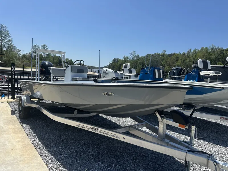 Slide: The Image of 2025 Xpress Skiff 185 boat on trailer, displayed outdoors under clear blue sky. - 2