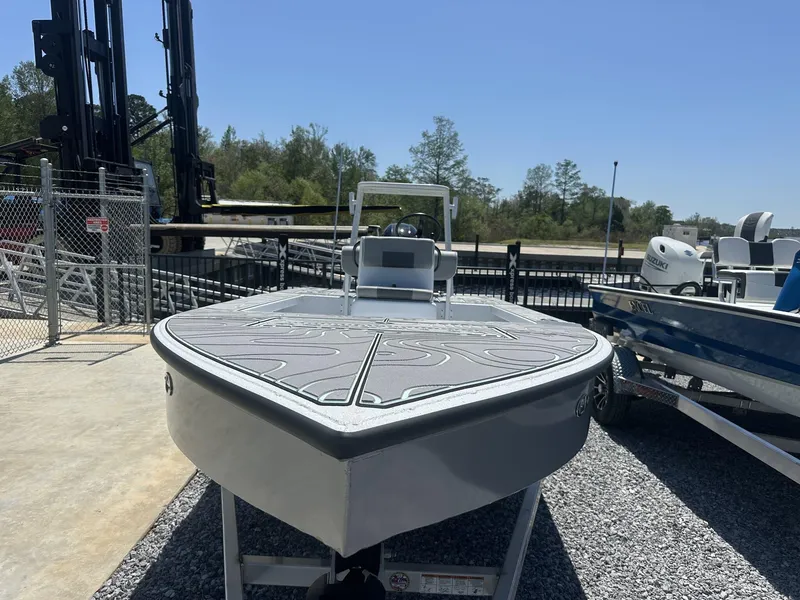 Slide: The Image of 2025 Xpress Skiff 185 boat displayed outdoors on gravel surface. - 6