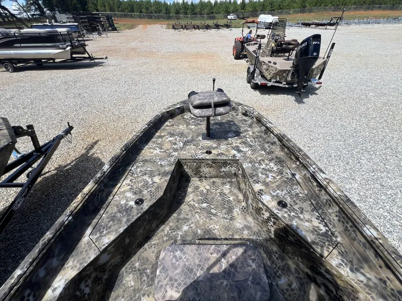 Slide: The Image of 2025 Excel Bay Pro 203 Elite boat with camouflage design in a gravel lot. - 3