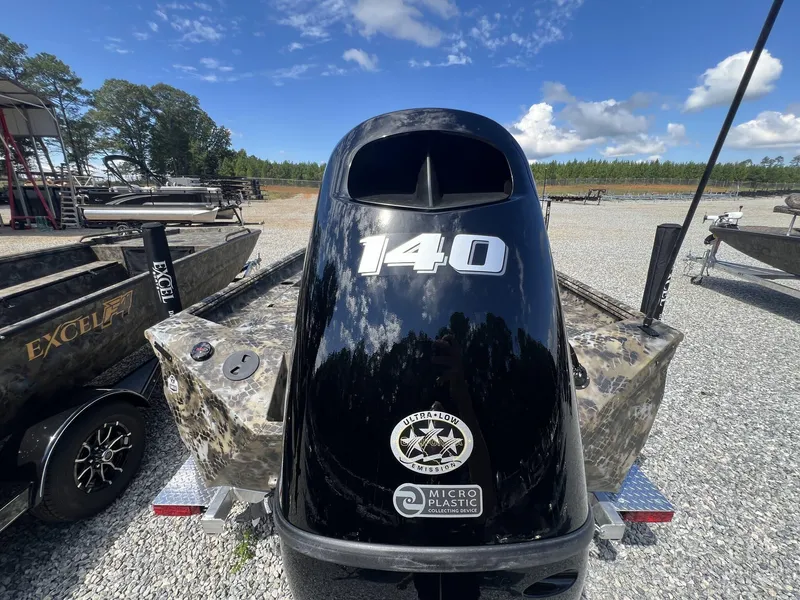 Slide: The Image of 2025 Excel Bay Pro 203 Elite boat with 140 HP engine, parked outdoors. - 6