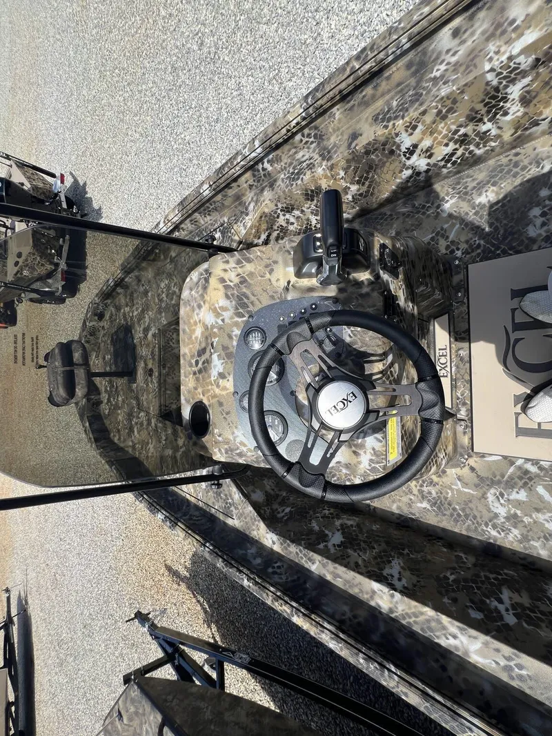 Slide: The Image of 2025 Excel Bay Pro 203 Elite boat interior with camo design and steering wheel. - 7