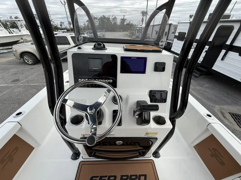 Slide: The Image of 2025 Sea Pro 230 Bay boat dashboard with steering wheel and navigation controls. - 11