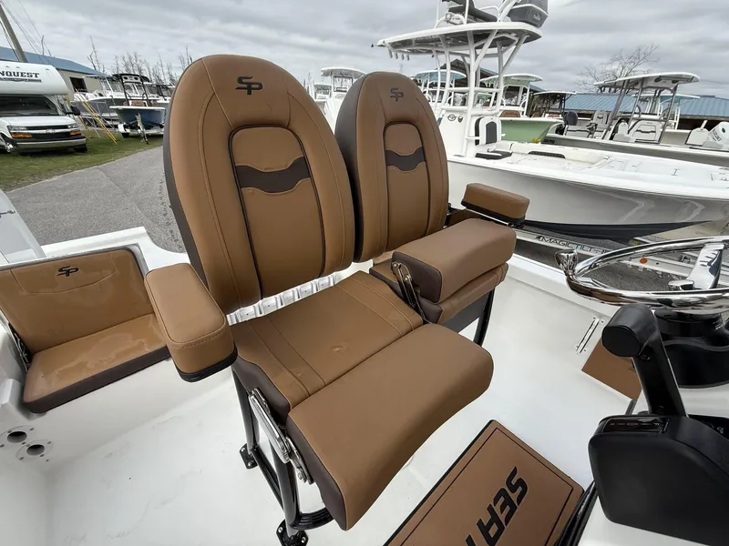 Slide: The Image of 2025 Sea Pro 230 Bay boat with brown leather seats and steering console. - 3