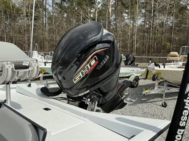 Slide: The Image of 2025 Xpress Hyper-Lift Series H22B boat with Yamaha outboard motor in a wooded area. - 4