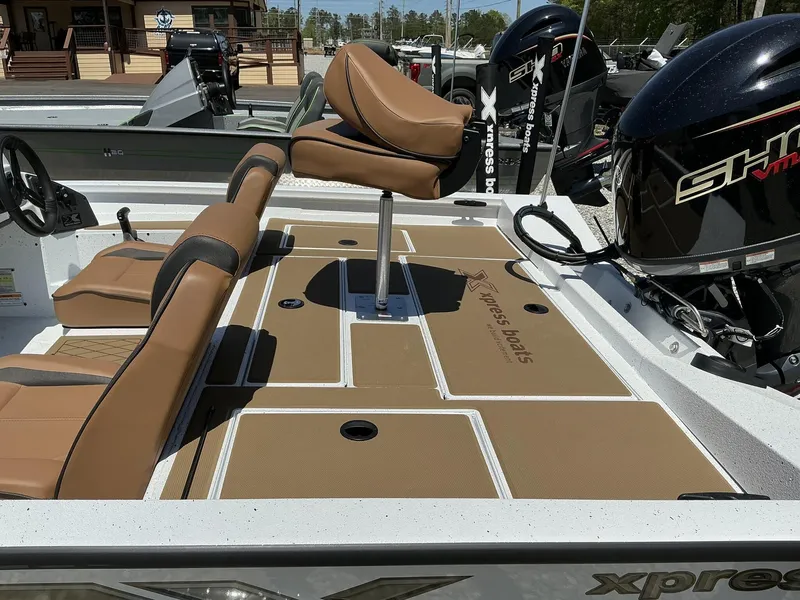 Slide: The Image of 2025 Xpress Hyper-Lift Series H18 bass boat interior with tan seating and powerful engine. - 6