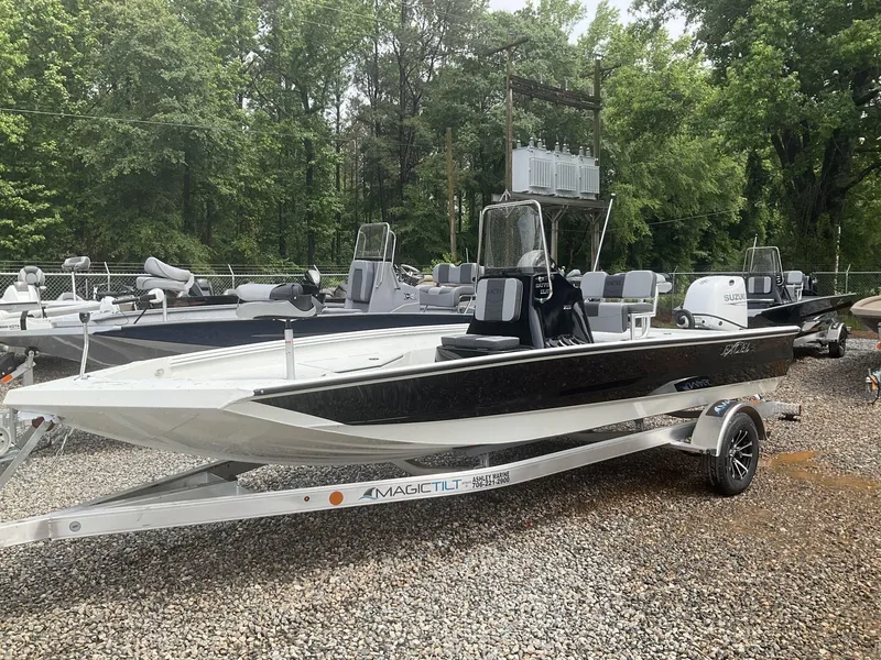 Slide: The Image of 2025 Excel Bay Pro 203 Elite boat on trailer, surrounded by trees. - 4