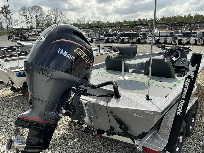 Slide: The Image of 2025 Xpress Hyper-Lift Bass Series boat with Yamaha engine, parked on gravel lot. - 11