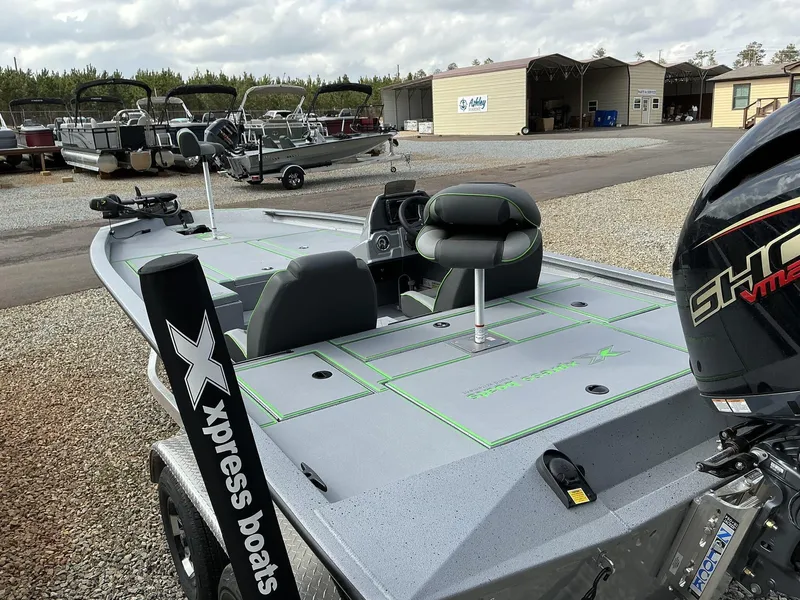 Slide: The Image of 2025 Xpress Hyper-Lift Bass Series boat with sleek design and powerful engine, parked outdoors. - 13