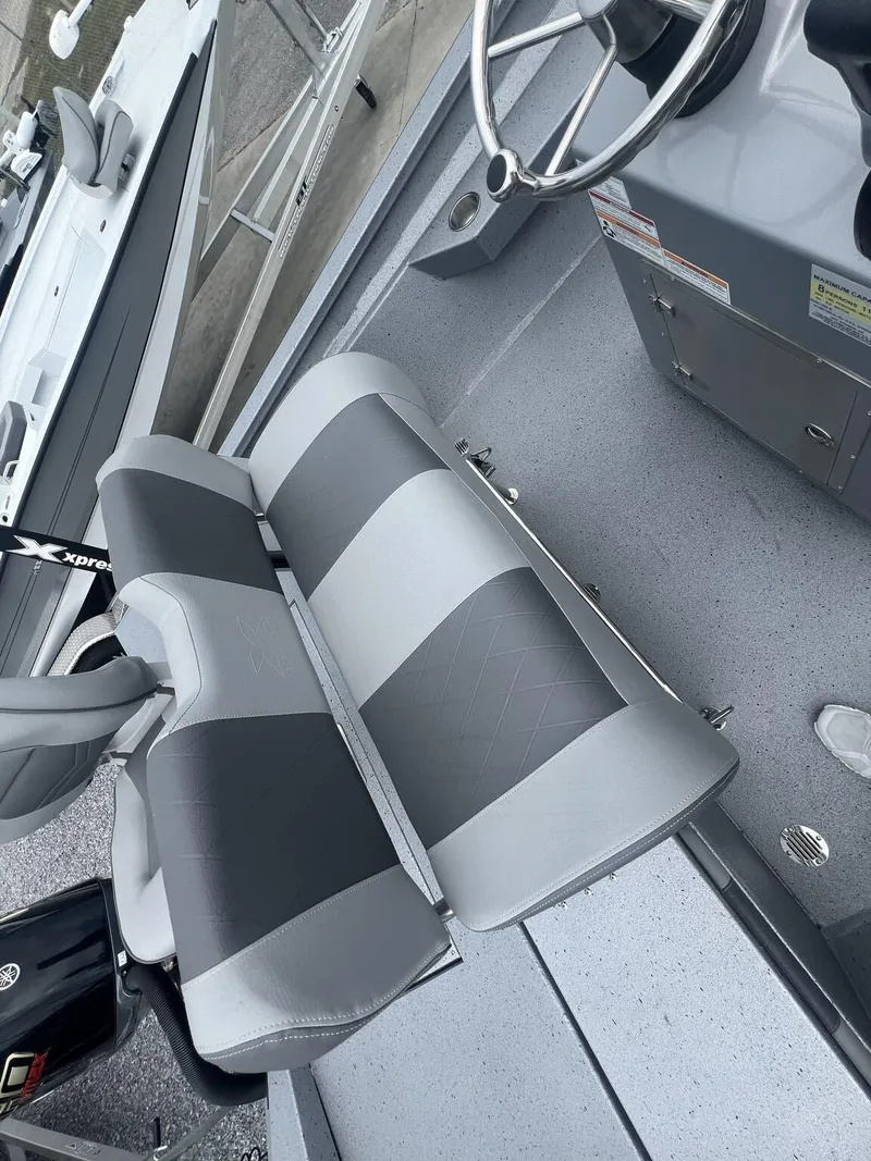 Slide: The Image of 2025 Xpress Hyper-Lift Series H22B boat interior with gray seating and steering wheel. - 14